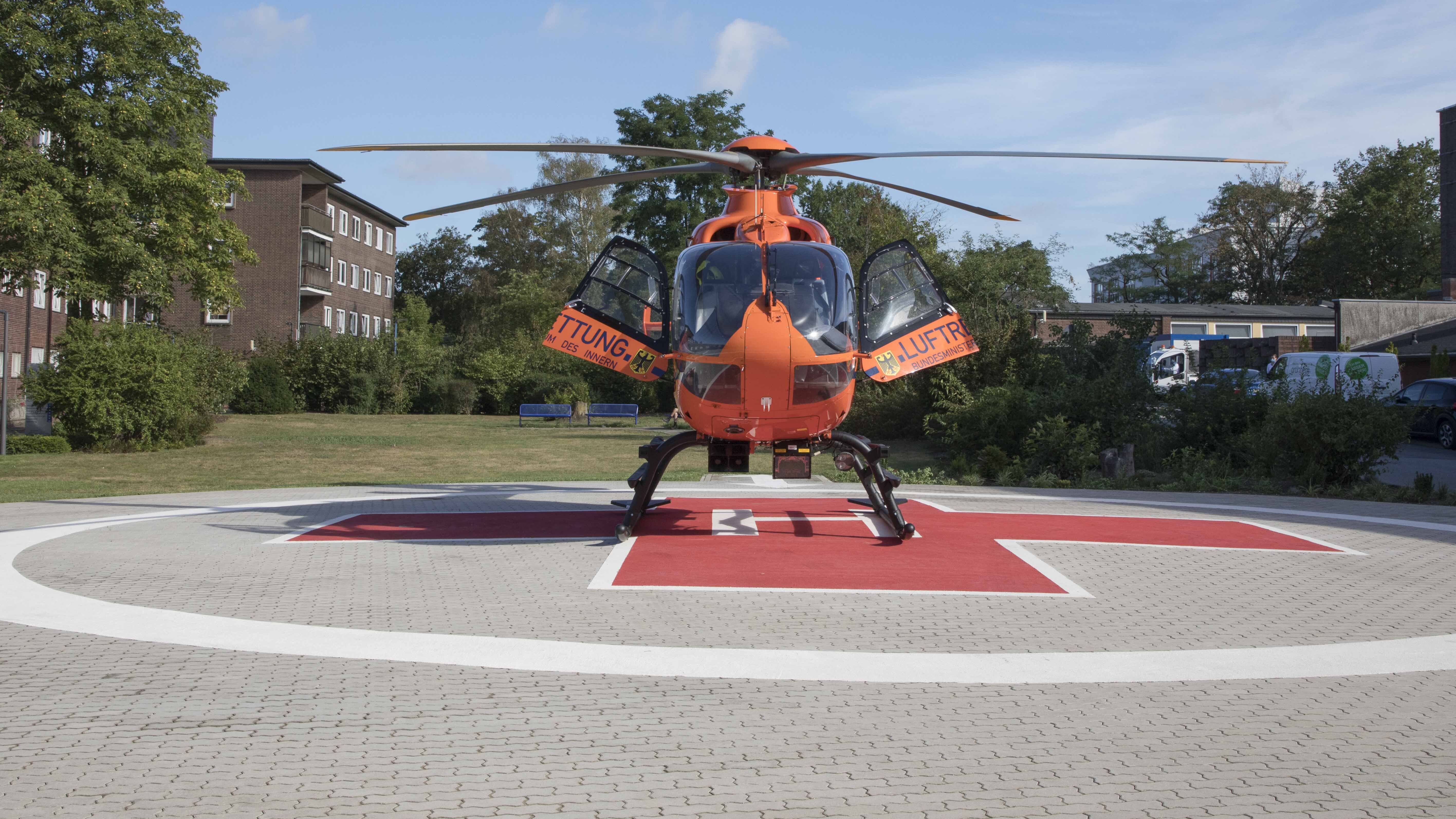 Ein Foto eines Helikopters, der mit offenen Türen auf unserem Helikopter-Landesplatz steht. 