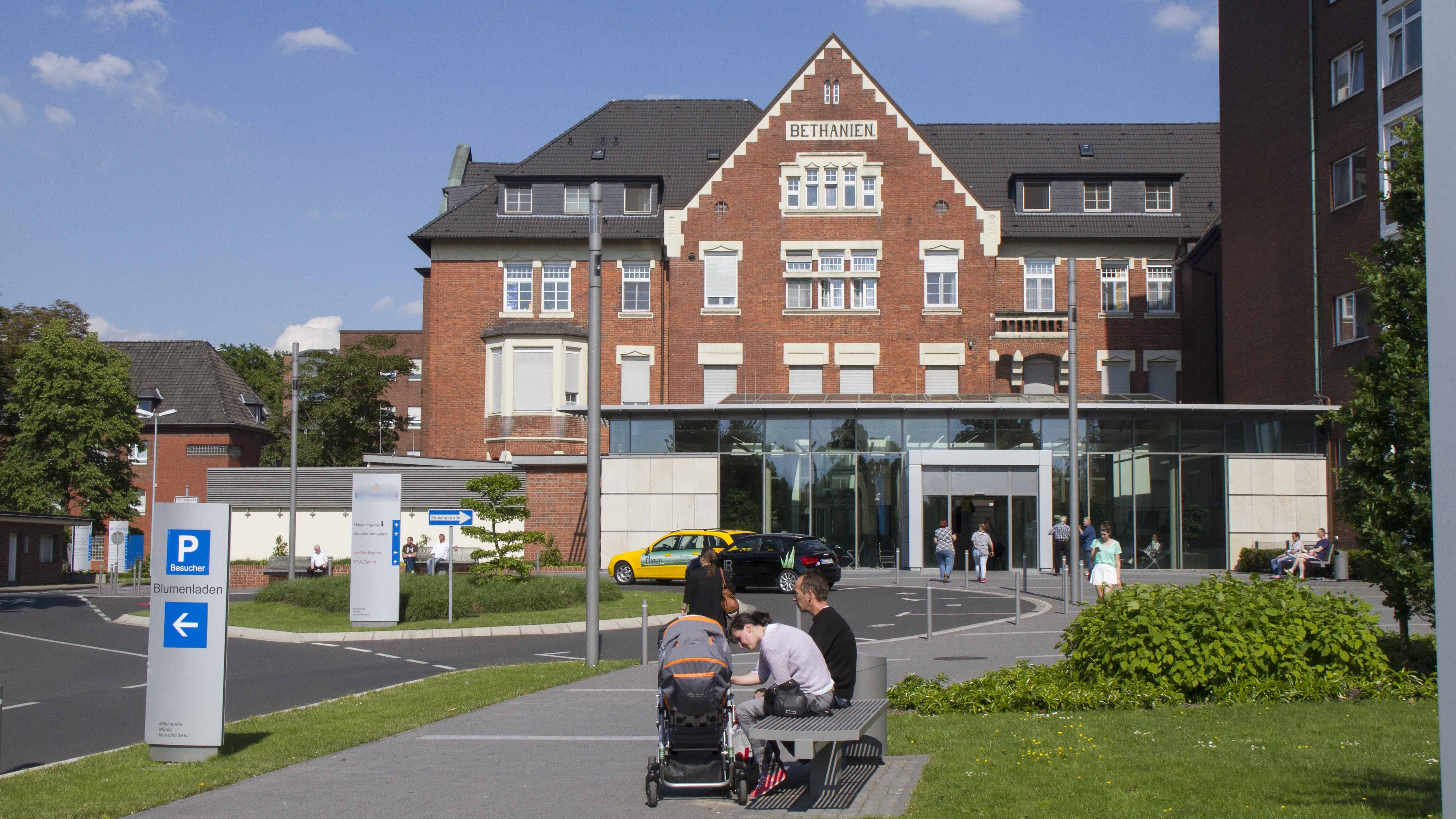 Auf dem Bild ist die Frontansicht unseres Krankenhauses zu sehen mit dem davorliegenden Außenbereich. 